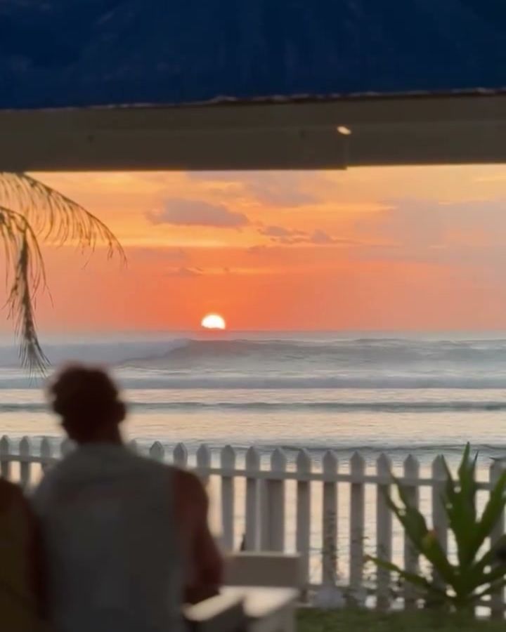 Guest at a table watching the sun set over the Ujung Bocur point from Lani's Resto, Tanjung Setia