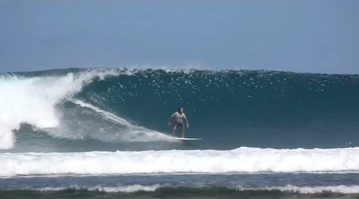 Surfer dropping into a clean left-hand wave at Ujung Bocur (Karang Nyimbor), Tanjung Setia